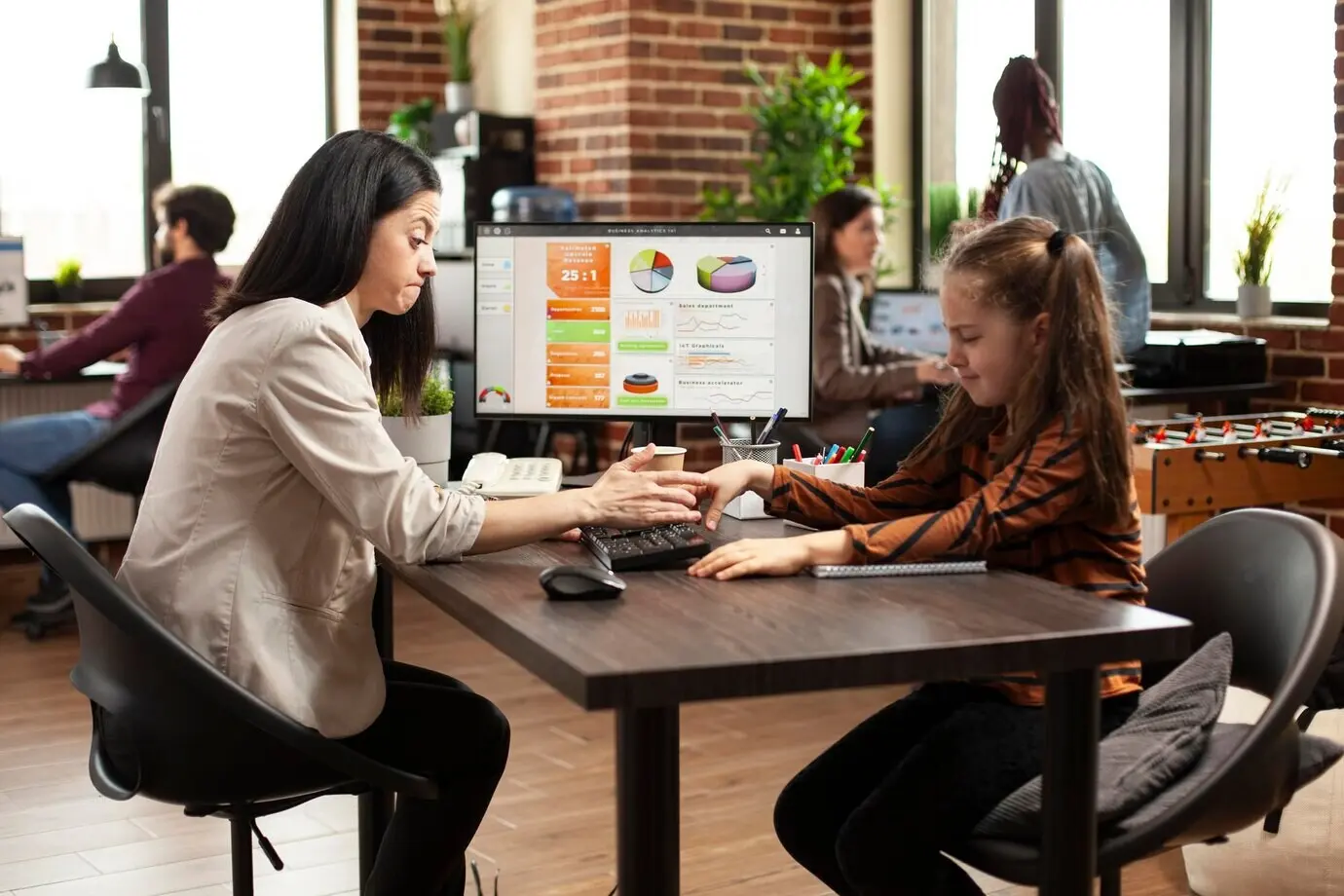 Niña juguetona molestando a su mamá en el trabajo.