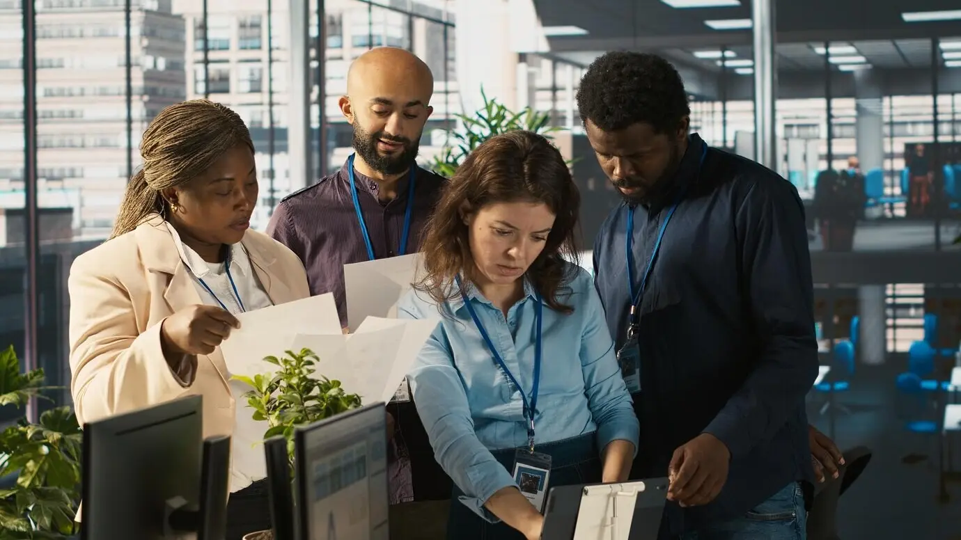 Retrato de empleados sonrientes en una oficina, trabajando juntos para finalizar un proyecto.